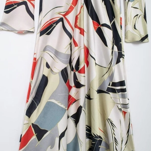 Elegant satin maxi dress featuring red and black geometric prints with a cinched waist design
