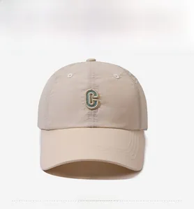 Detailansicht einer beigen schnelltrocknenden Baseballkappe mit grüner C-Stickerei vorne