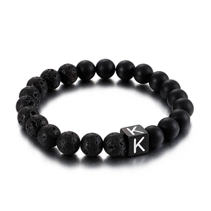 Lava stone and onyx bead bracelet featuring a stainless steel letter K charm on white base