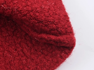 Macro di tessuto a maglia rosso con trama mohair e fili metallici argentati brillanti