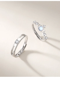 Detail of silver couple rings showing moonstone inlay and crown design with zircons