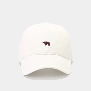 Close-up of brown polar bear embroidery on minimalist off-white cotton baseball cap