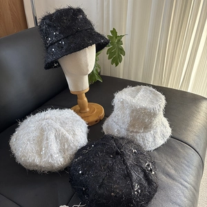Détail de paillettes sur chapeau cloche et béret à franges sur du cuir