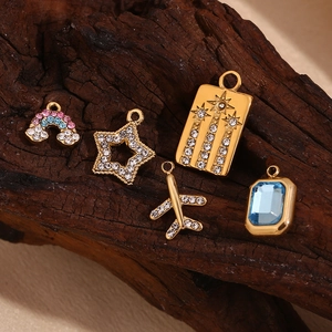 Detail of 14K gold plated mini charms with rainbow clouds, stars and blue gemstones