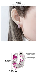 Detail showing 10mm silver huggie earrings with pink and white cubic zirconia stones