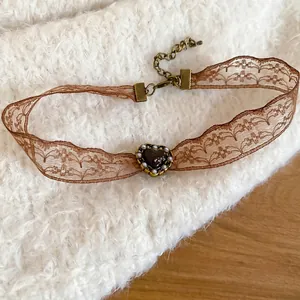 Vintage French lace choker with a deep red resin heart pendant and bronze lobster clasp