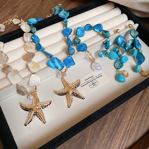 Detailed set of shell necklaces and starfish earrings in a velvet display box