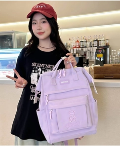 Purple school backpack for girls featuring bear embroidery and a large front pocket
