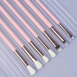 Detail of 7-piece pink eye makeup brush set with rose gold ferrules on lavender background