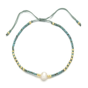 Detail of bohemian handmade beaded bracelet with green vintage beads and a freshwater pearl