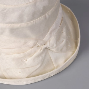Elegant beige Lyocell linen sun hat featuring a decorative bow with pearl embellishments