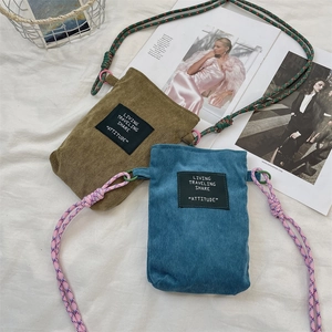 Detail of corduroy phone bags with climbing rope straps and woven labels on fabric