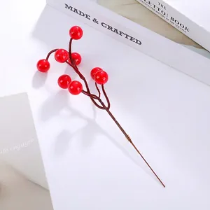 Macro shot of a red artificial winterberry branch with glossy berries on white background