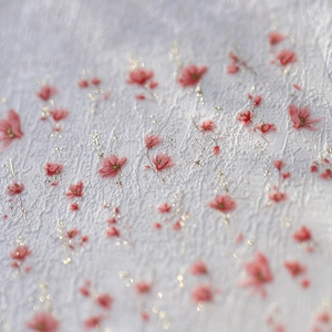 Textured white nail art sticker with pink floral patterns and gold foil accents