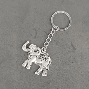 Detailed view of a silver vintage alloy elephant keychain on a gray textured background