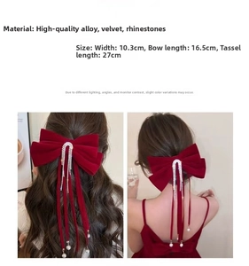 Dettaglio del fiocco in velluto rosso con frange di strass e ciondoli di perle eleganti