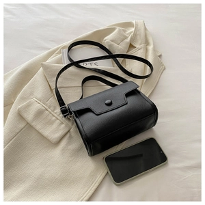 Detail of black litchi grain leather handbag with silver hardware and adjustable strap