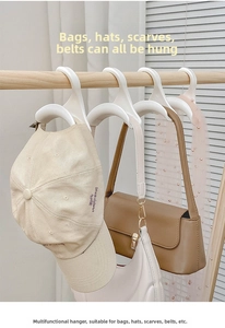 Detailopname van een witte kunststof opberghaak voor tassen en petten aan een houten roede