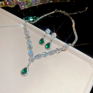 Macro view of water drop green gemstone necklace and earrings with sparkling crystals