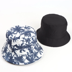Detail view of double-sided bucket hats with palm tree print and solid black cotton fabric