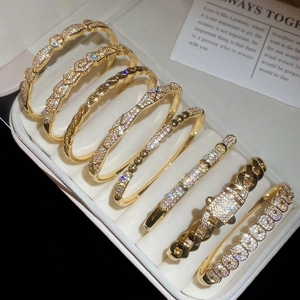 Close-up of gold-plated bracelets featuring micro-pave zircons and vintage textures