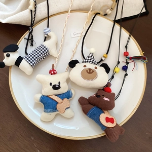 Detailed view of handmade fabric animal pendants with embroidery on ceramic tray