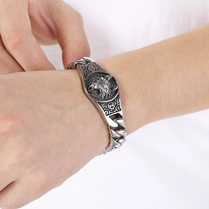 Macro view of a silver punk wolf head relief and thick Cuban chain bracelet for men