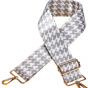 Détail de la bandoulière pied-de-poule gris avec boucle dorée réglable et mousqueton