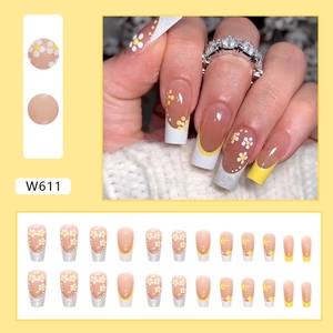 Detail of French nude pink press-on nails with daisy floral designs and silver glitter