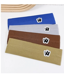 Close-up of four ribbed knit headbands in blue, grey, brown, and green with W embroidery