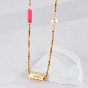 Double-layered gold necklace with pink bead, pearl, and mountain charm on white background