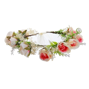 Detail shot of a floral crown featuring pink-white roses and green leaves on a vine base