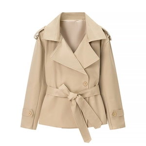 Dettaglio di un trench corto beige con rever classici e cintura in vita annodata