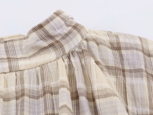 Vue détaillée de la couture plissée et de la texture du tissu à carreaux sur l'épaule
