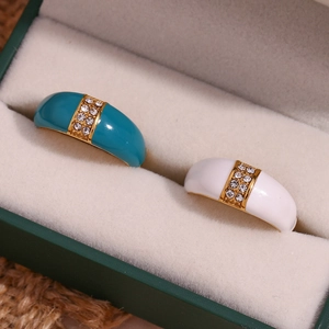Detail of 18K gold plated rings with blue and white enamel inlay and crystals