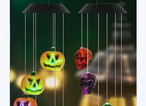 Detail of Halloween solar wind chimes with glowing pumpkin and skull LED lights for patio decor
