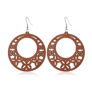Close-up of vintage hollow wooden hoop earrings with metal hooks on a white surface