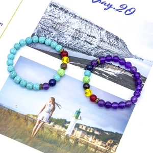 Detailed macro shot of turquoise and purple chakra energy beaded bracelets with metal spacers