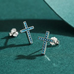 Retro sterling silver cross stud earrings with turquoise stones on green velvet