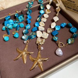 Detailed view of jewelry set featuring seashell charms, starfish pendants and pearls