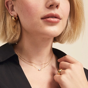 Double-layered gold necklace with blue square zircon pendant and chunky hoop earrings