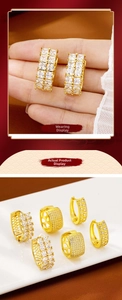 Detailed close-up of gold clasp earrings featuring rectangular and round zirconia stones