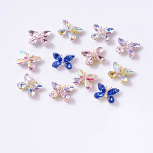 Vue macro de 11 bijoux d'ongles papillon en cristal 3D avec bases en métal brillant