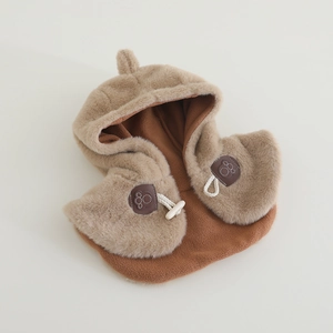 Dettaglio cappello invernale in peluche con finta pelliccia e chiusura con alamari crema