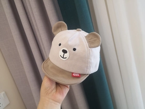 Detailed close-up of striped baby bear ear cap showing soft fabric and cute embroidery
