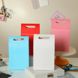 Minimalist kraft paper gift bags with handles in light blue, red, white, and pink