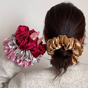 Set of four glossy satin scrunchies in gold and burgundy for high ponytail styles