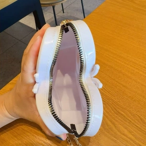 Détail d'un sac cœur blanc en gelée avec fermeture éclair et bandoulière chaîne