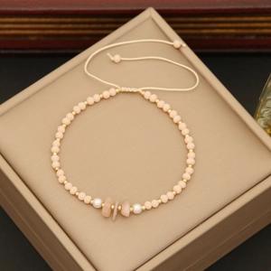 Close-up of bohemian beaded bracelet with natural pink stones, pearls and golden beads