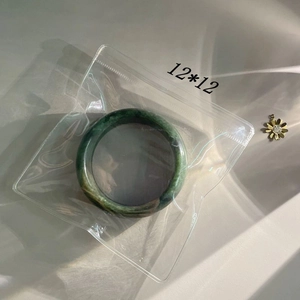 Detail of 12x12cm anti-oxidation jewelry storage bag with green jade bangle inside